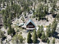 Mountain cabin with deck and solar panels, nestled in the woods at 4730 Cougar Ridge Trl, Mount Charleston, NV 89124
