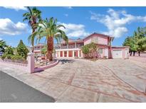 Pink two-story house with palm trees and a long driveway at 5290 Obannon Dr, Las Vegas, NV 89146