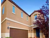 Two-story house with brown garage door and landscaping at 9033 Savvy Seam Ct, Las Vegas, NV 89149