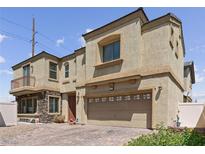 Two-story house with a large tan facade, two-car garage, and stone accents at 3508 Discovery Downs Ct, North Las Vegas, NV 89081