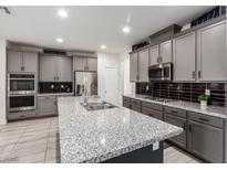 Spacious kitchen with granite countertops and gray cabinets at 306 Dedication Ave, Henderson, NV 89011