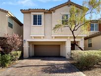 Two-story house with tan siding, brown garage door, and landscaped yard at 8473 Bellery Ave, Las Vegas, NV 89143