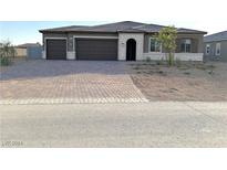 Two-story house with a three-car garage and landscaped yard at 4701 E Sandalwood Dr, Pahrump, NV 89061