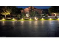 Night view of house exterior with landscape lighting at 6116 Twilight Cove Cir, Las Vegas, NV 89131