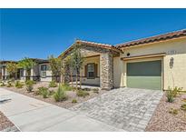 Single-story home with stone accents, a green garage door, and a landscaped front yard at 370 Canary Song Dr, Henderson, NV 89011