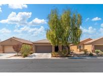 One-story home with a tan exterior, attached garage, and mature landscaping at 4039 Welsh Pony St, Las Vegas, NV 89122