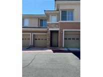 Tan two-story townhome with attached garage and landscaping at 656 Peachy Canyon Cir # 203, Las Vegas, NV 89144