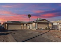 Single-story home with a two-car garage and landscaped yard at 4474 El Carnal Way, Las Vegas, NV 89121