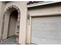 Attached garage with arched entryway and brick detailing at 8240 Aurora Peak Ave, Las Vegas, NV 89131