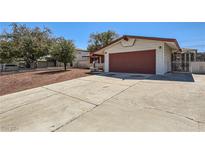 House exterior with driveway, attached garage, and mature trees at 2221 Palora Ave, Las Vegas, NV 89169