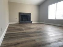 Bright living room featuring a fireplace and wood-look flooring at 3614 Calmosa St, Las Vegas, NV 89103