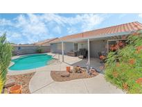 Inviting backyard oasis featuring a sparkling pool, covered patio, and lush landscaping at 5116 Vista Del Rancho Way, North Las Vegas, NV 89031