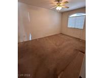 Spacious carpeted bedroom with ceiling fan and window at 1300 S Arlington St # 120, Las Vegas, NV 89104