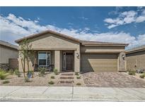 Tan house with a brown door and brick driveway at 7369 Rosenberger St, Las Vegas, NV 89166
