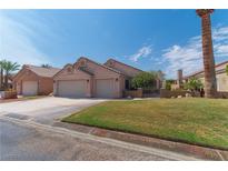 Two-story house with a two-car garage and landscaped lawn at 1214 Country Club Dr, Laughlin, NV 89029