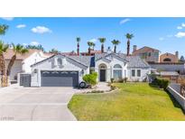 Single-story home with gray garage door and landscaped yard at 3652 Brian Ct, Laughlin, NV 89029