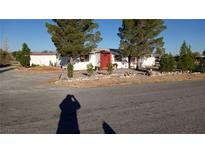 Single story home with red door and landscaping at 5200 Bonnie St, Pahrump, NV 89048