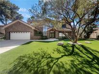 Brick home with two-car garage and manicured lawn at 17 Hummingbird Ln, Henderson, NV 89014