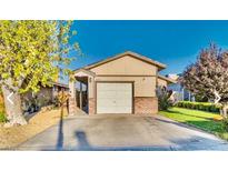 Tan house with a brick facade, one car garage, and a small front yard at 2031 San Simeon St, Las Vegas, NV 89108