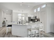 Modern kitchen with white cabinets and island at 6128 Casper Sands Ct, North Las Vegas, NV 89031