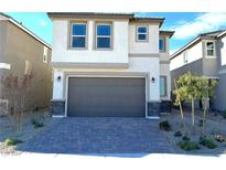 Two-story house with gray garage door and stone accents at 7215 Stockton Dunes St, North Las Vegas, NV 89084