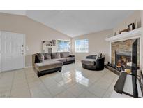 Comfortable living room with a fireplace, vaulted ceiling and tile flooring at 5420 Centurion Ct # 202, Las Vegas, NV 89122