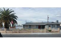 Ranch style home with gray exterior, red door and block wall fencing at 5156 Treasure Ave, Las Vegas, NV 89122
