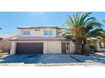 Two-story house with brown garage door and desert landscaping at 7513 Council Ave, Las Vegas, NV 89128