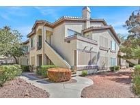 Two-story condo building with a walkway and landscaping at 5710 E Tropicana Ave # 1187, Las Vegas, NV 89122