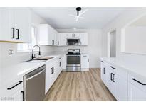 Modern white kitchen with stainless steel appliances at 528 Kings Ave, North Las Vegas, NV 89030