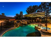 Inviting pool area with waterfall, spa, and shaded seating at 2231 S Monte Cristo Way, Las Vegas, NV 89117