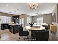 Open concept kitchen and dining area with island, dark cabinetry, and modern lighting at 8493 Insignia Ave # 101, Las Vegas, NV 89178