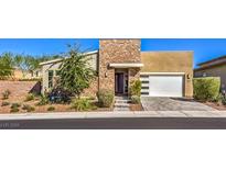 Single-story home with modern design, attached garage, and landscaped front yard at 2560 Bridle Oaks Ct, Henderson, NV 89044