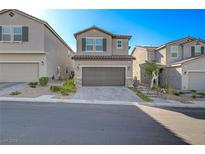 Two-story house with gray exterior, two-car garage, and landscaped front yard at 5403 El Nevero St, Las Vegas, NV 89166