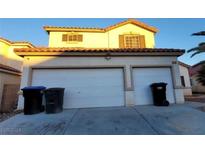Two-story house with a three-car garage and desert landscaping at 4116 Mattray St, North Las Vegas, NV 89032