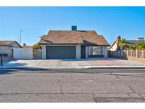 Single story home with attached garage and landscaped front yard at 3827 Silent Hill Dr, Las Vegas, NV 89147