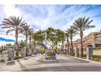 gated community entrance with palm trees and stone pillars at 805 Dana Hills Ct # 202, Las Vegas, NV 89134
