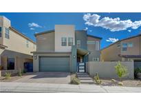Modern two-story house with gray siding, a green garage door, and landscaped front yard at 3345 Solento Ln, Las Vegas, NV 89044