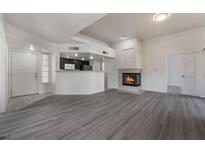 Bright living room with fireplace and wood-look floors at 7400 W Flamingo Rd # 2013, Las Vegas, NV 89147