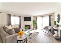 Living room with fireplace, gray couch, and sliding glass doors at 6857 Tamarus St # 101, Las Vegas, NV 89119