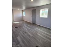 Bright living room with grey vinyl plank flooring and neutral walls at 1080 Shady Ln, Pahrump, NV 89060