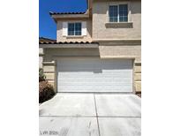 Two-car garage with white door and landscaping at 9460 Magnificent Ave, Las Vegas, NV 89148