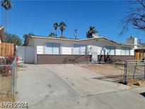 Ranch-style home with a large driveway and mature palm trees at 6232 Blair Way, Las Vegas, NV 89107