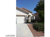 Two-story house with attached garage and landscaping at 10372 Pink Cloud Ct, Las Vegas, NV 89129