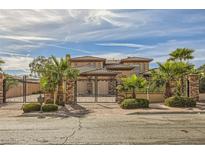 Two-story house with gated entrance, palm trees at 7797 Edna Ave, Las Vegas, NV 89117