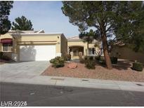 Tan two-car garage house with landscaping and driveway at 10404 Frostburg Ln, Las Vegas, NV 89134