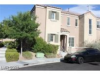 Tan two-story townhome with a black car parked in front at , Las Vegas, NV 89149