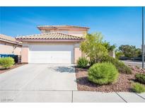 Two-story house with attached garage and landscaped front yard at 5516 Madigan Ct, Las Vegas, NV 89118