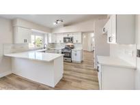 Modern white kitchen with U-shaped island and quartz countertops at 1941 Toscanini Way, North Las Vegas, NV 89032