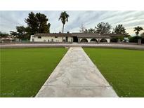 Large home with a spacious front lawn and walkway at 6010 Annie Oakley Dr, Las Vegas, NV 89120